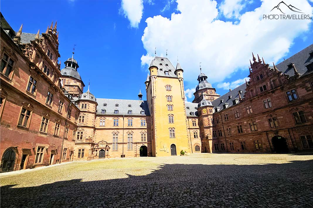 Blick vom umbauten Innenhof auf die Mauern und dem gelben Turm von Schloss Johannisburg