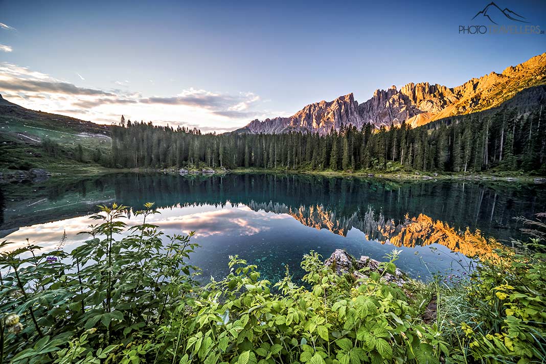 Der Karersee im Abendlicht mit den angestrahlten Bergen ringsum