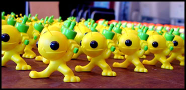 Gros plan de jouets en plastique jaunes avec des boutons verts, conçus pour les jeux en famille ou en classe, ambiance ludique et colorée, idéal pour divertir les enfants et stimuler leur créativité.