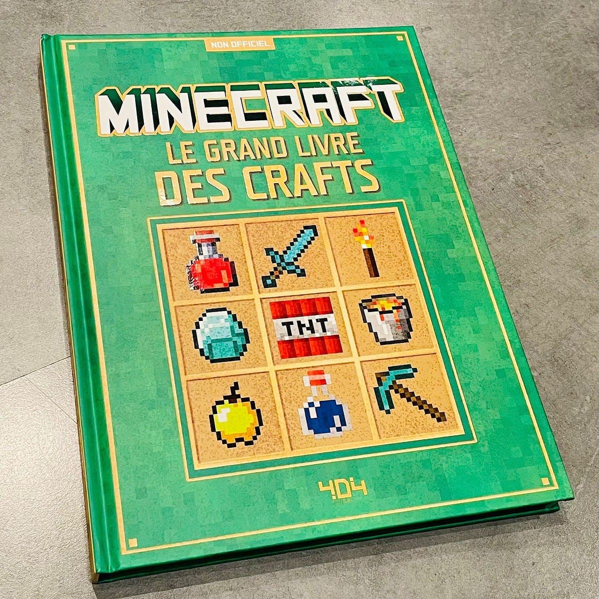 Couvreur du livre Minecraft "Le grand livre des crafts" avec illustrations pixel art d'objets et outils liés au jeu vidéo.