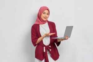 外籍移工|重建處移工健康關懷 11/9 最終場 專業女性外籍勞工使用筆記型電腦,展現多元國際人力資源管理。.