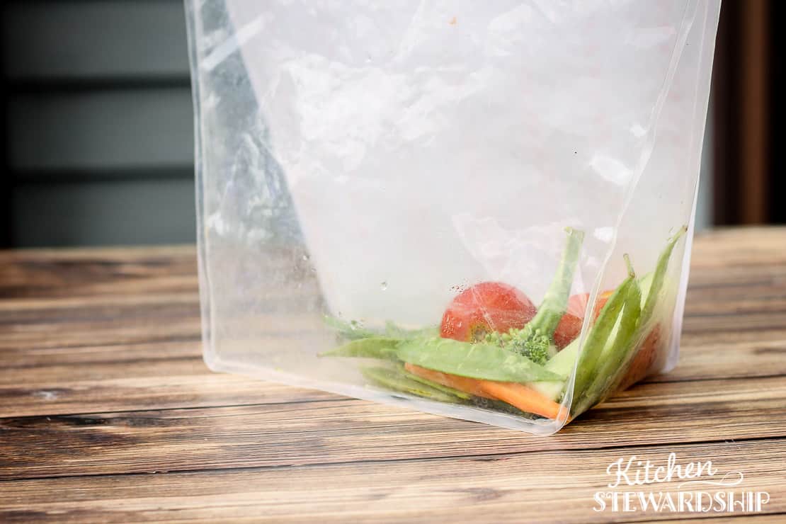 reusable storage bag standing up filled with raw veggies