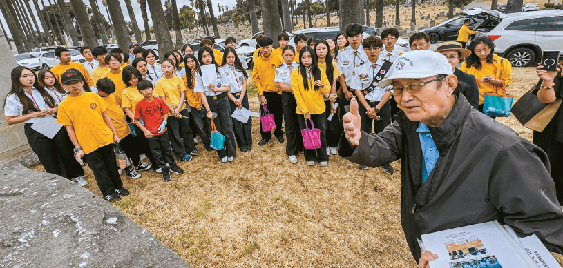 Byungyong Min explains forgotten independence patriots' graves to Korean American teens at Rosedale Cemetery