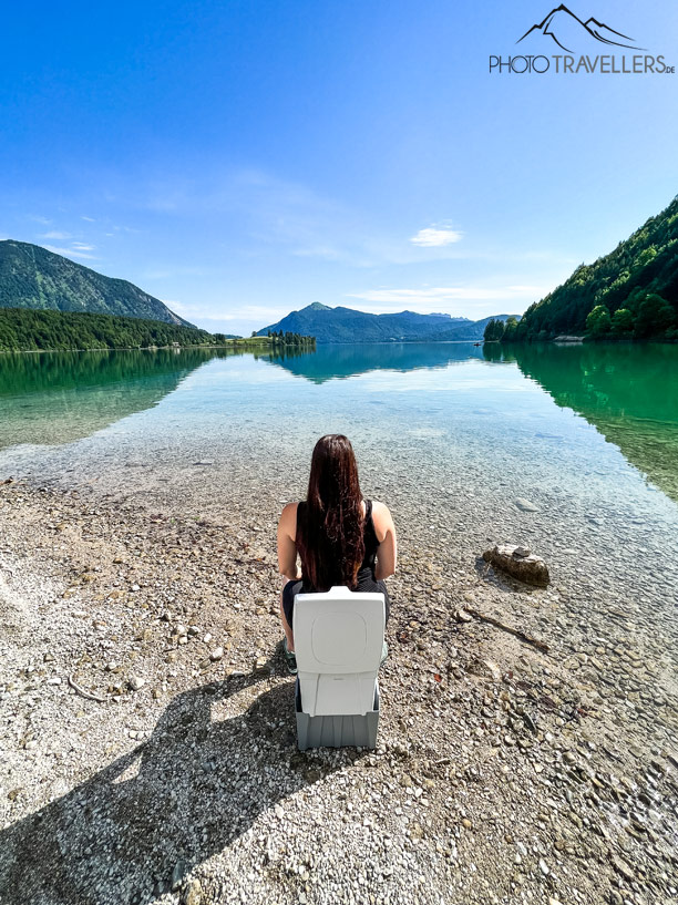 Biggi sitzt auf der Campingtoilette Trobolo WandaGo mit See-Blick
