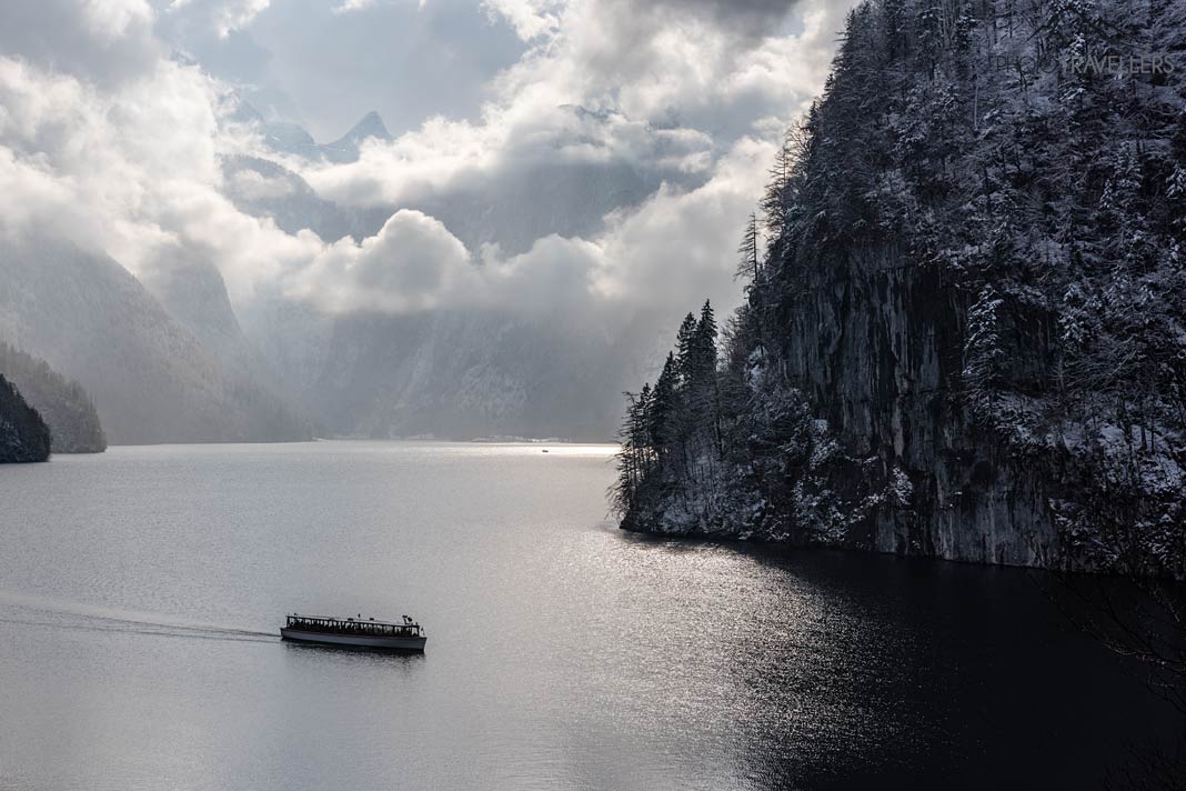 Der Blick vom Malerwinkel-Aussichtspunkt auf den Königssee im Winter, auf dem ein Boot fährt