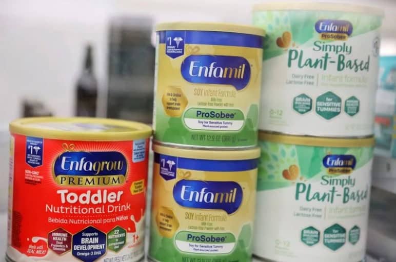 Measuring scoop inside a container of powdered baby formula, focusing on infant nutrition and safety.